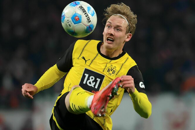 Julian Brandt schaut auf den Ball und versucht ihn mit seinem waagrecht ausgestreckten rechten Bein anzunehmen