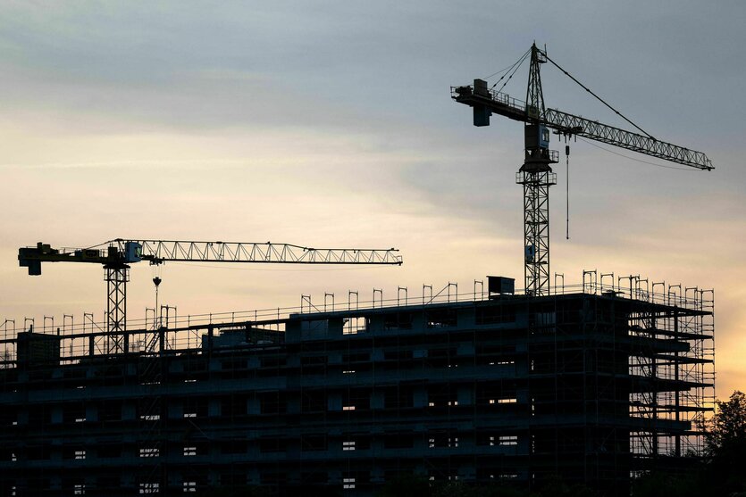 Zwei Kräne stehen hinter dem Rohbau für ein Bürogebäude