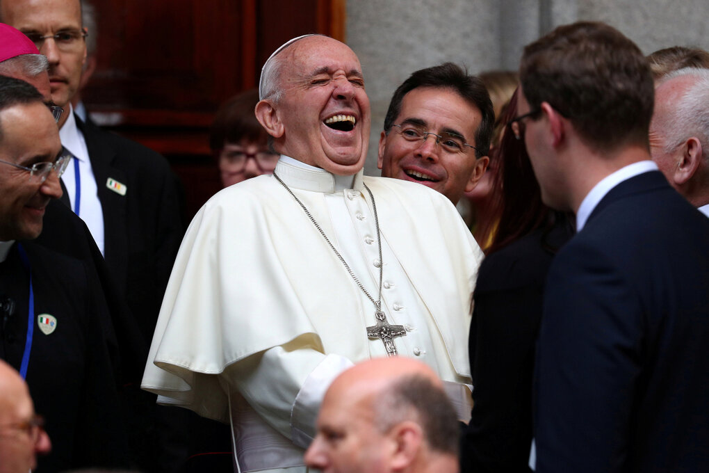 Papst Franziskus wird von Menschen umringt und lacht