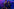 Kyle Alessandro steht mit zwei Tänzern in blau-violettem Licht auf einer Bühne und hält sich eine Hand vor seinen Mund