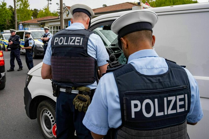 Zwei Polizisten kontrollieren an einer Grenze