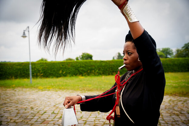 Künstlerin Tuli Mekondjo schwenkt in Nauen bei einer rituellen Performance ein Haarwedel