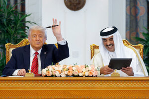 Zwei Männer, Trump und al-Thani, unterschreiben Papiere und lächeln