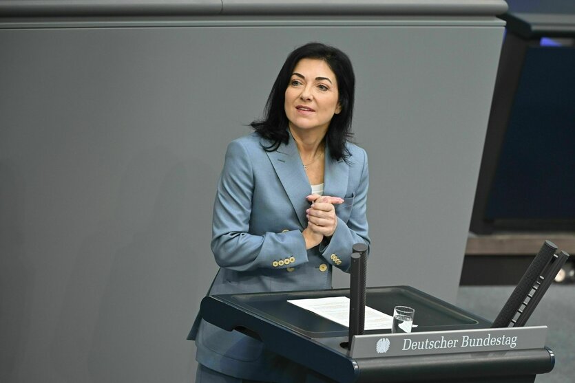 Frau gestikuliert am Rednerpult