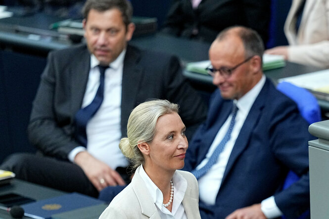 Zu sehen ist die rechtsextreme AfD-Chefin Alice Weidel, im Hintergrund die Köpfe der neuen Bundesregierung Lars Klingbeil und Friedrich Merz.