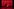 Ein rot glimmender Hintergrund auf einer ansonsten dunklen Theaterbühne