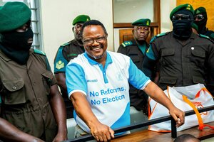 Tundu Lissu lacht, er ist von Uniformierten umringt