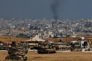 Die Grenze zum Gazastreifen, davor sieht man israelische Panzer, im Hintergrund steigt Rauch aus den Ruinen auf