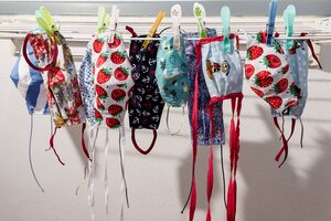 Bunte Coronamasken aus Stoff auf einer Wäscheleine