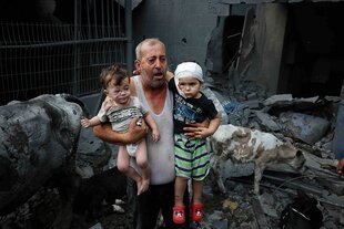 Ein palästinensischer Flüchtling trägt seine Enkel aus dem von Israel bombardierten Nuseirat-Camp.