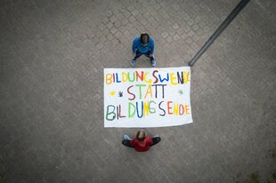 Zwei Mädchen stehen um ein Plakat herum