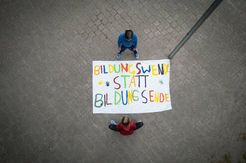 Zwei Mädchen stehen um ein Plakat herum