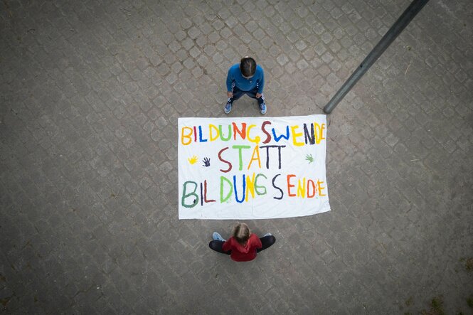 Zwei Mädchen stehen um ein Plakat herum