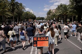 Demonstrierende Menschen mit Schild "Se Alquila"