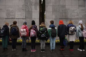 Kinder stehen vor einem Mahnmal