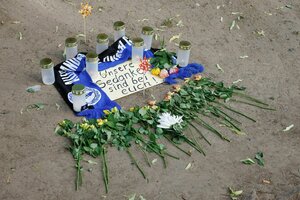 Rosen, Kerzen, ein Fanschal von Arminia Bielefeld und ein zettel auf dem steht: 