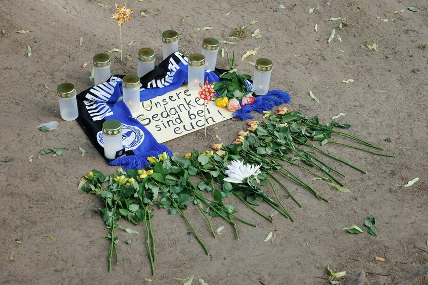 Rosen, Kerzen, ein Fanschal von Arminia Bielefeld und ein zettel auf dem steht: "Unsere Gedanken sind bei Euch"