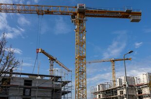 Das Bild zeigt Kräne auf einer Baustelle.