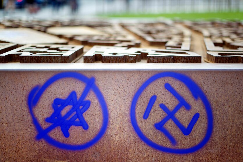 An eine Gedenkstätte ist ein durchgestrichener Davidstern und ein Hakenkreuz gesprayt