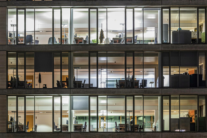 Außenansicht eines beleuchteten Bürogebäudes bei Nacht