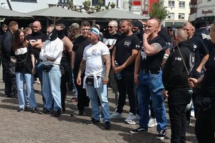 In der Herforder Fussgängerzone steht eine Grupe Menschen in weiss-schwarzen T-shirts