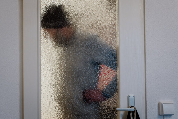 Ein Mann verschwommen hinter der Milchglasscheibe einer Tür