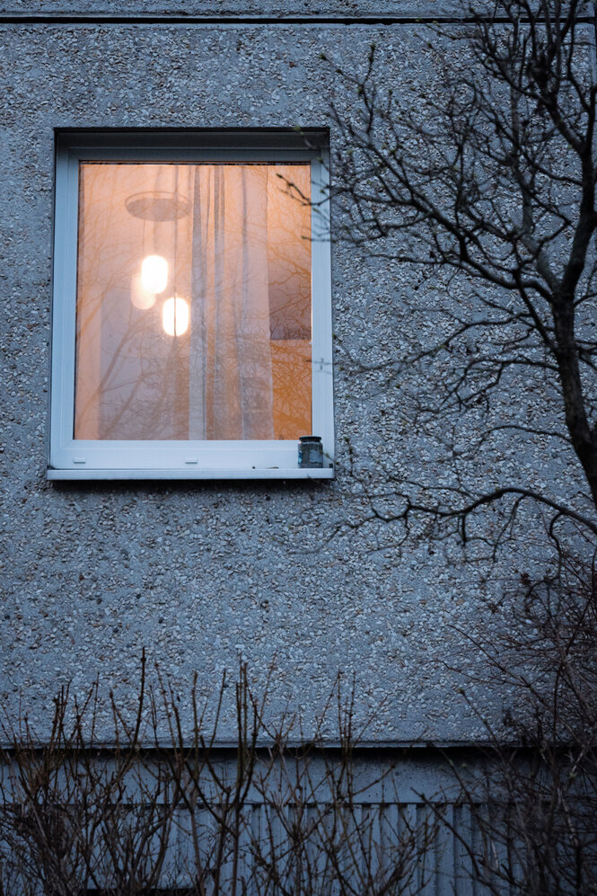 Ein erleuchtetes Fenster in einem Plattenbau