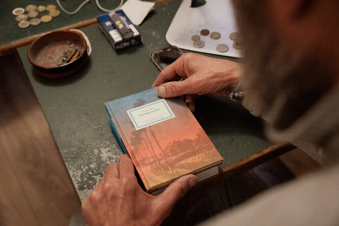 Ein Buch, ein Aschenbecher, ein paar Münzen