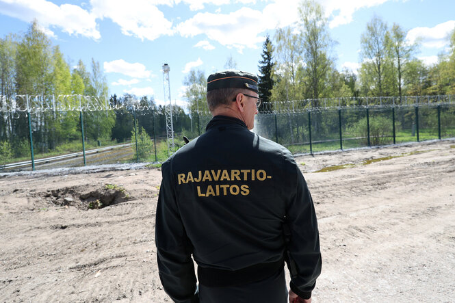 Ein finnischer Grenzsoladt am Grenzzaun zu Russland