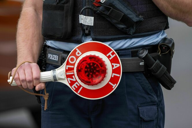 Ein Bundespolizist hält eine Kelle in den Händen