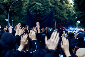Menschen halten bei einem protest ihre Hände in die Höhe