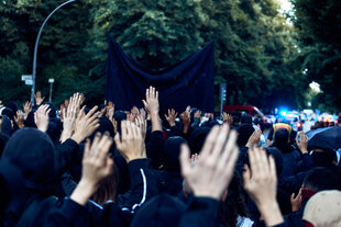 Menschen halten bei einem protest ihre Hände in die Höhe