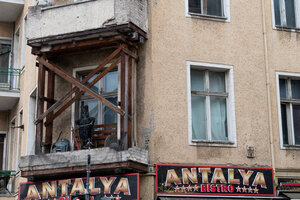 Abgestützter Balkon mit einer Hexen-Holzstaue