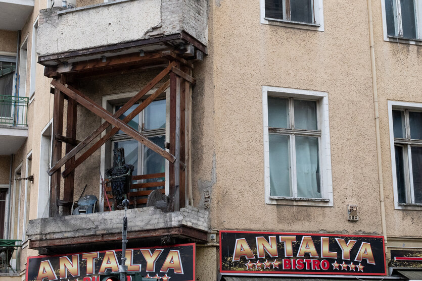 Abgestützter Balkon mit einer Hexen-Holzstaue
