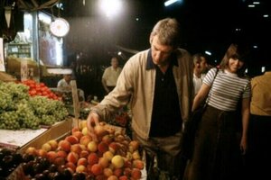 Filmszene mit Donald Sutherland als John Klute und Jane Fonda als Bree Daniels: Die Figuren laufen am Abend über einen Markt. John Klute schaut sich eine Auslage mit Pfirsischen an, Bree Daniels läuft hinter ihm in seine Richtung und schaut lachend zu ih