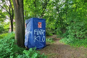 Eine Kabine aus blauer Plane mit der Aufschrift 