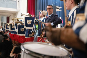 Cem Özdemir steht in einem Fanfarenzug und trommelt