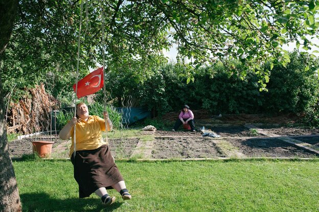 Frau mit türkischer Fahne in der Hand auf einer Schaukel