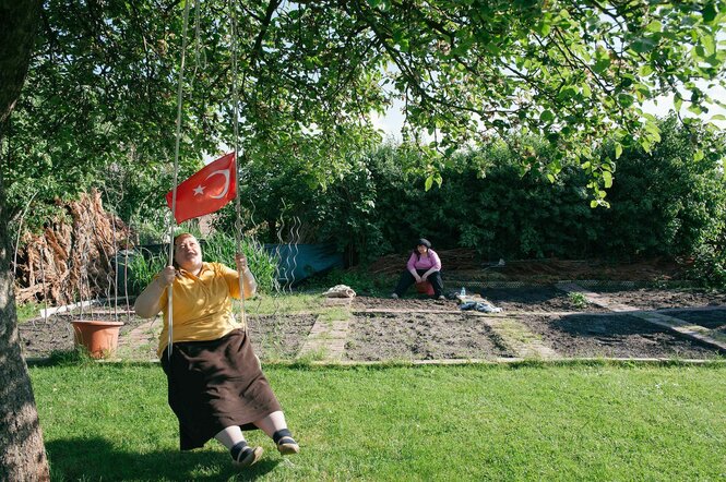 Frau mit türkischer Fahne in der Hand auf einer Schaukel