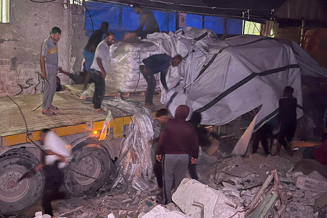 Palestinensische Arbeiter entladen einen Lastwagen mit Hilfsgütern