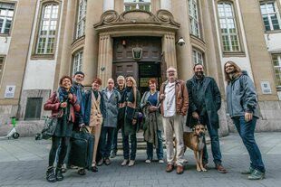 Eine Gruppe von Menschen steht vor dem Gebäude des Landesgerichts Frankfurt am Main