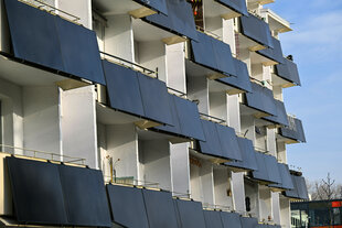 viele Solarmodule vor einem Balkon