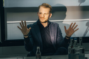 Tim Klüssendorf, sein Gesicht wiurd von der Sonne beschienen, er hat beide Hände erhoben