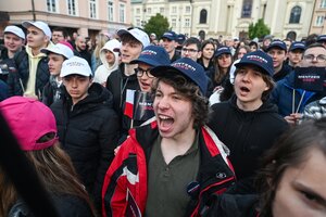 Junge Männer mit Basecaps auf dem Kopf stehen auf einer Kundgebung und schreien rum