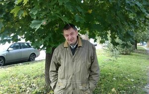 Ein Mann steht unter einem Baum