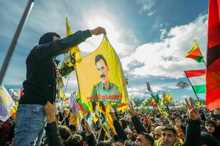 Menschen schwenken beim Neujahrsfest Öcalan-Fahne