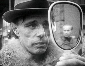 Joseph Beuys mit Hut schaut in den Spiegel