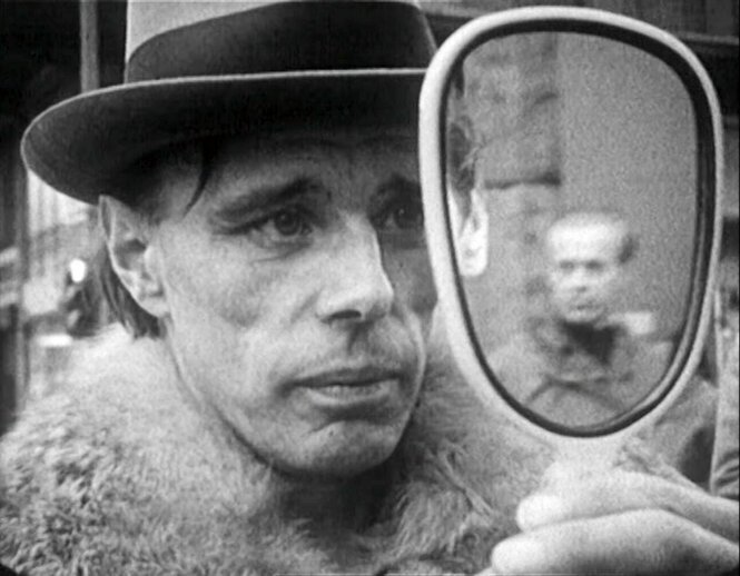 Joseph Beuys mit Hut schaut in den Spiegel