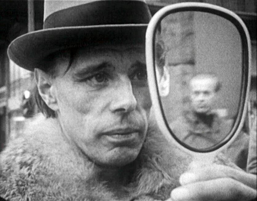 Joseph Beuys mit Hut schaut in den Spiegel