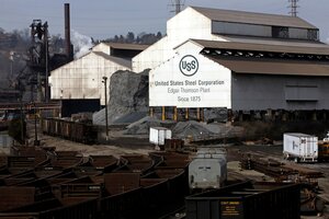 Die Hallen eines Stahlwerkes, im Vordergrund Gleise mit Güterwaggons